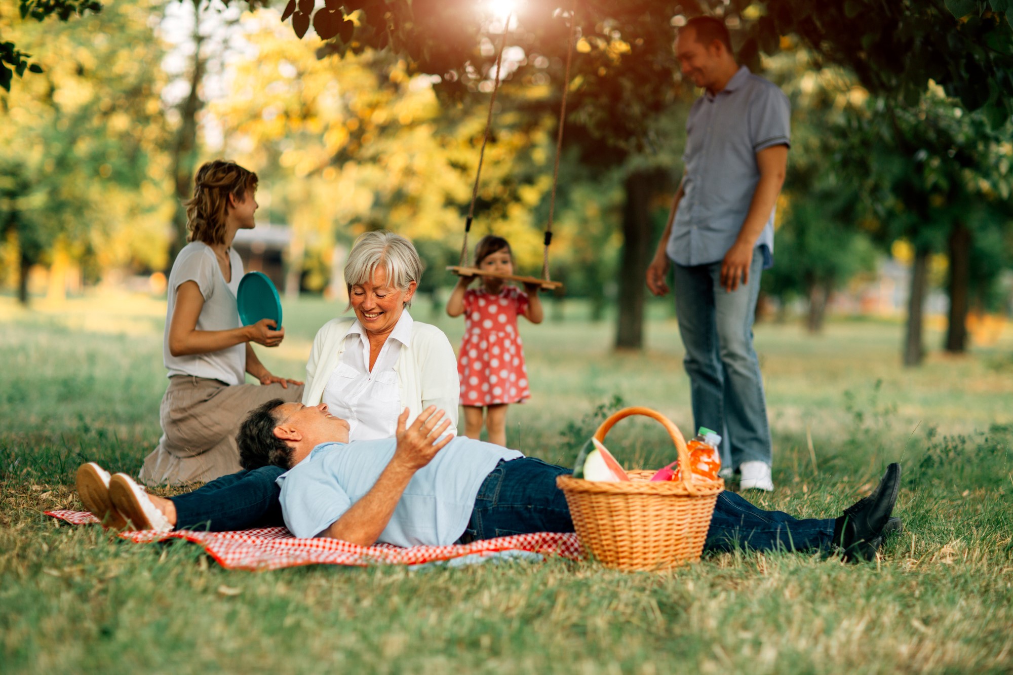 Family of three generations having picnic in a park