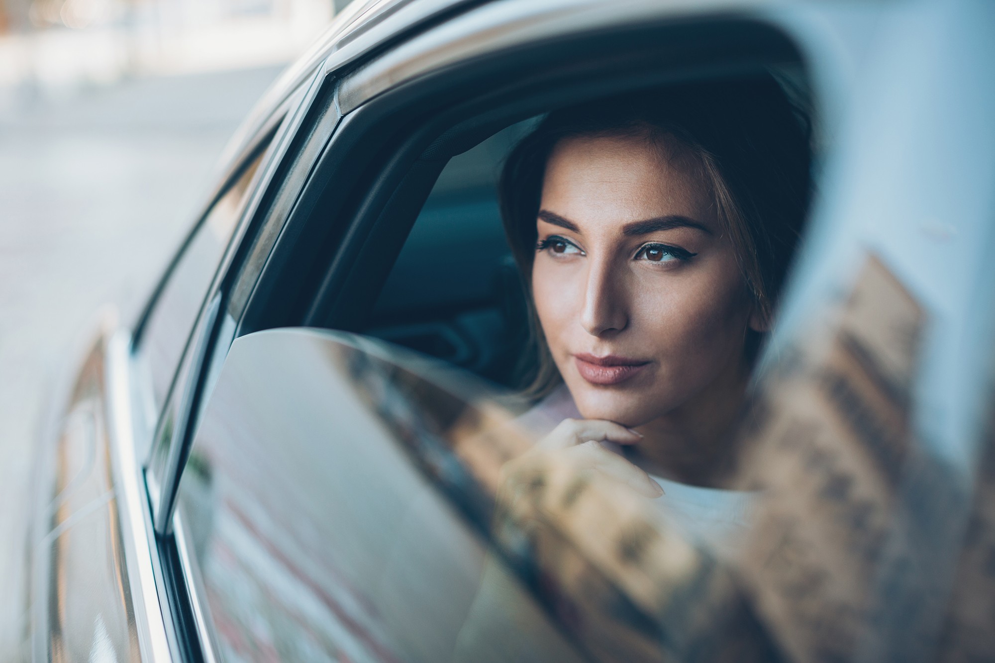 Successful woman looking out of a car window