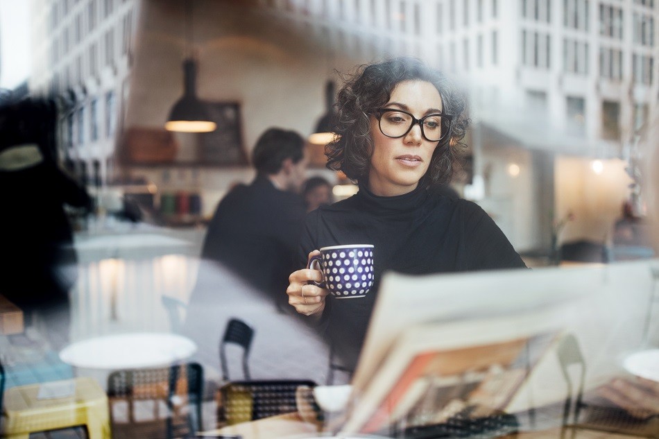 Picture of a woman with mug working at a cafe