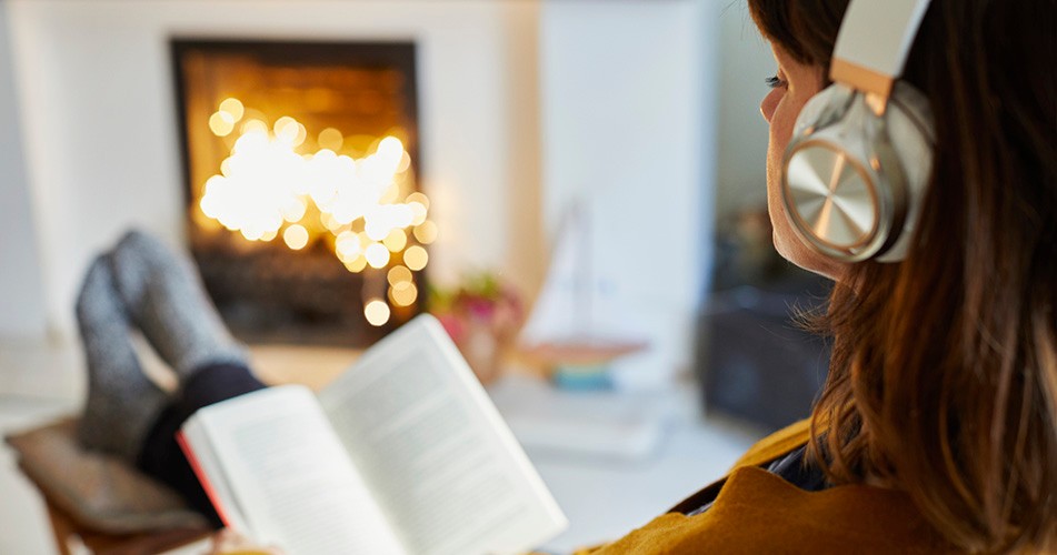 Picture of person reading a book by the fire