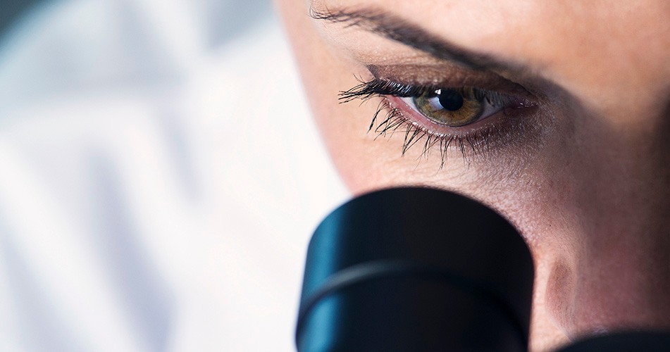 Picture of a woman looking through a microscope