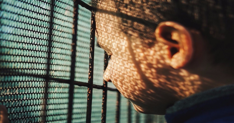 Close-up of man behind bars