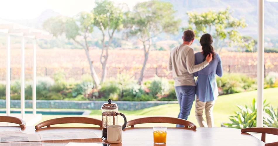 Couple standing on patio together looking over field