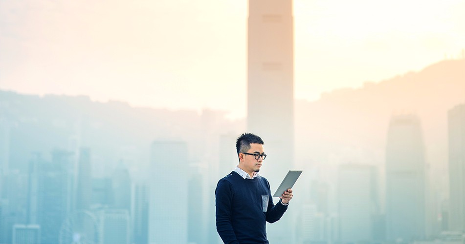 Picture of a man on tablet with city behind
