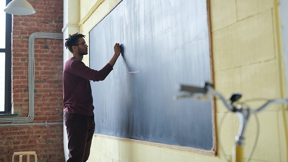 Picture of a person writing on a blackboard
