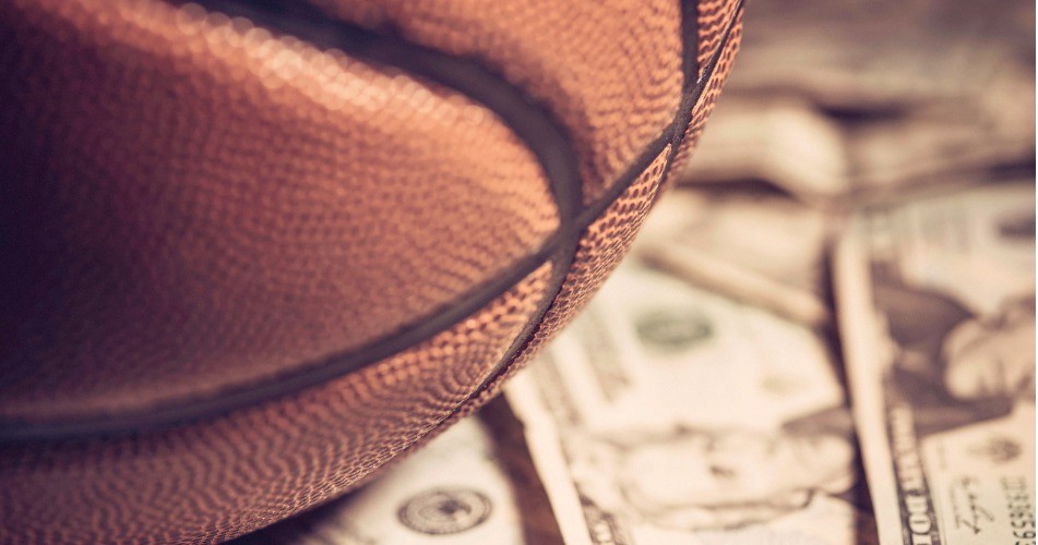Picture of  a basketball on top of American dollars