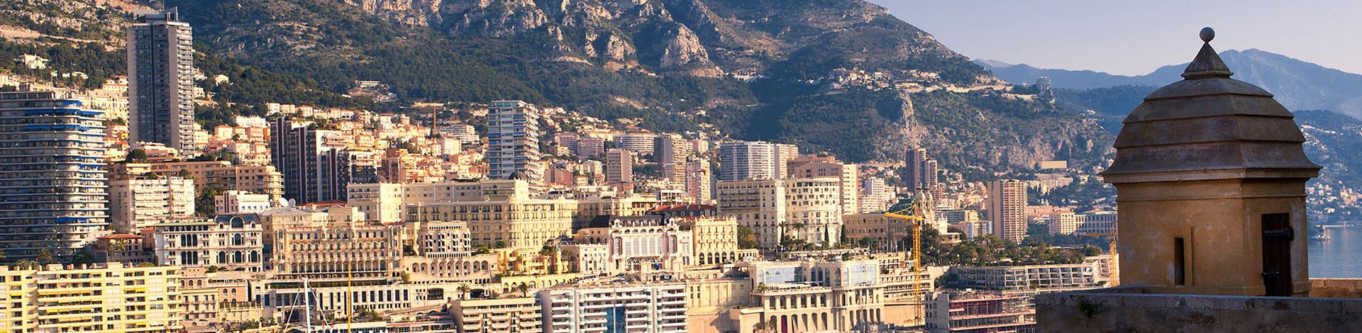 Harbour in Monaco with buildings and mountains in the background