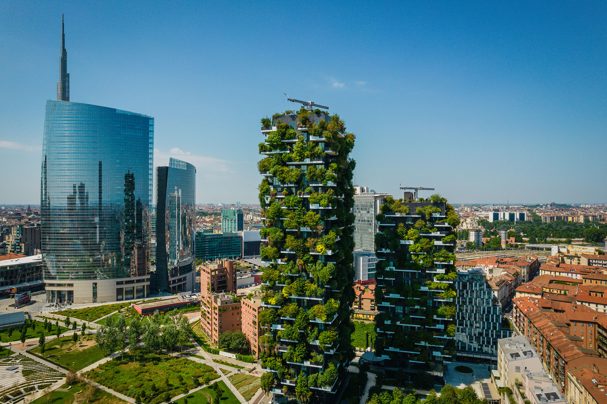 Milan skyline with two tower blocks adorned with plants in foreground