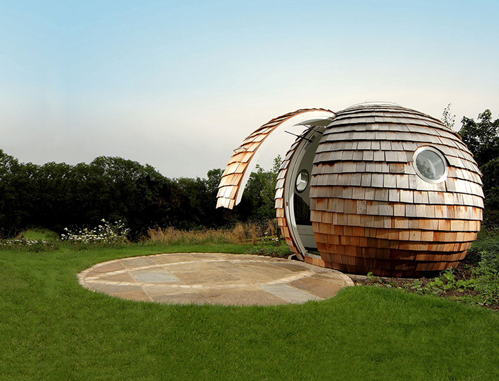 Futuristic spherical hut with upwards-opening door partially opened