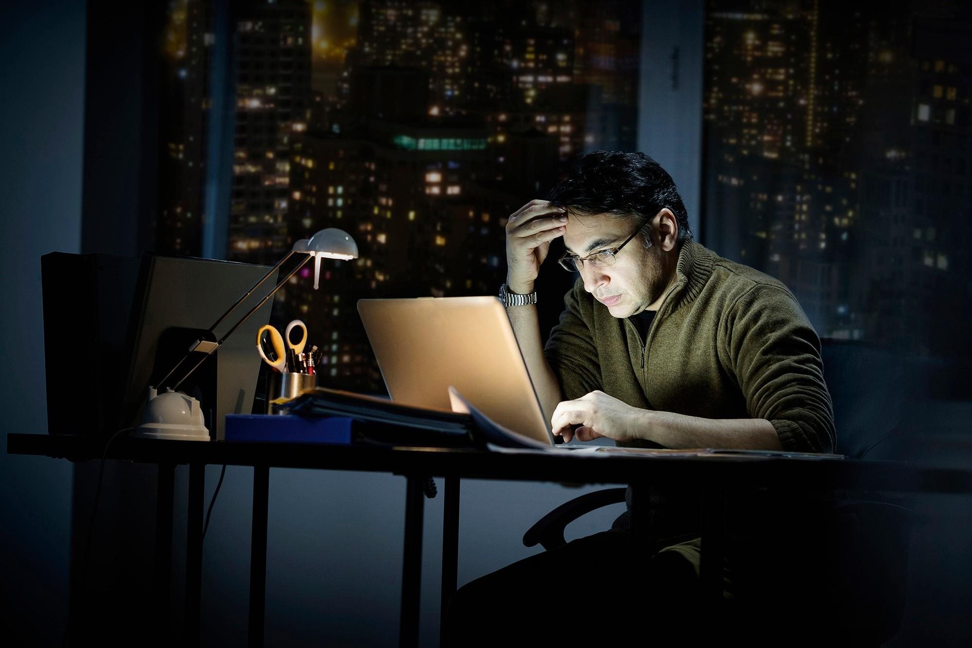 Man working on laptop in the dark