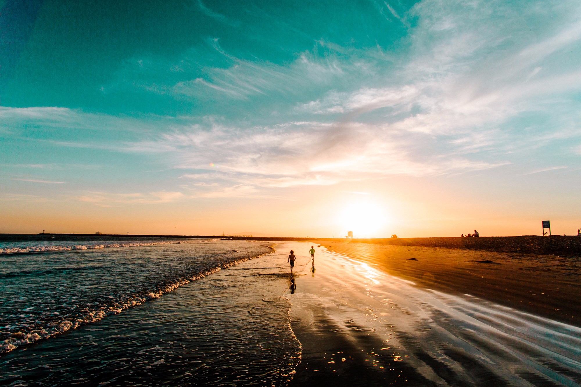 Children running on a beach in the sunset