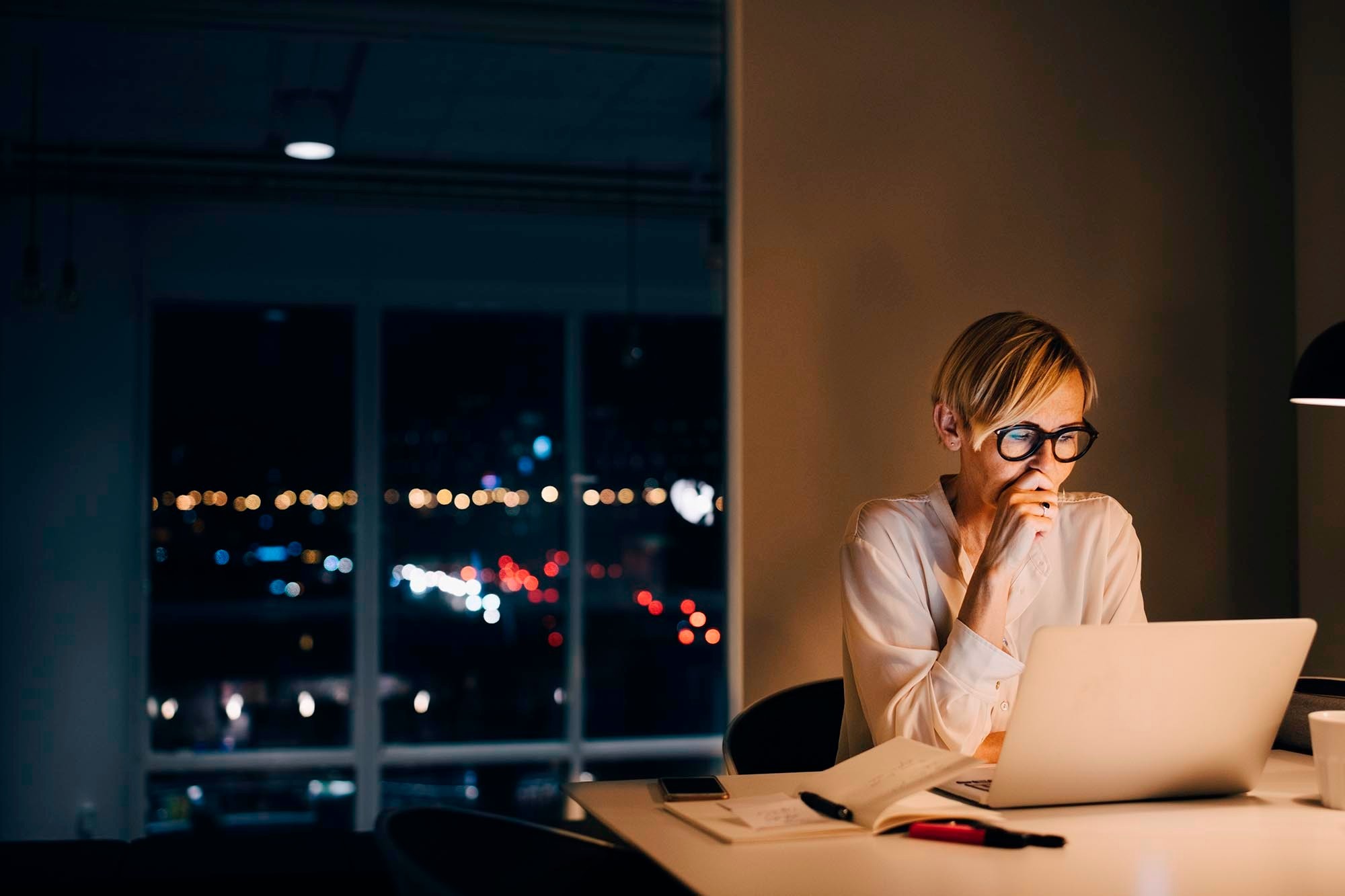 Picture of a business woman working overnight on her laptop