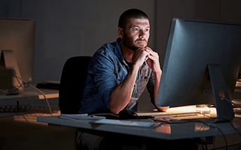 Man looking at monitor screen and concentrating 