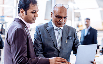 Two men having and discussion and looking at a laptop