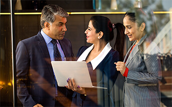 3 business people looking at laptop