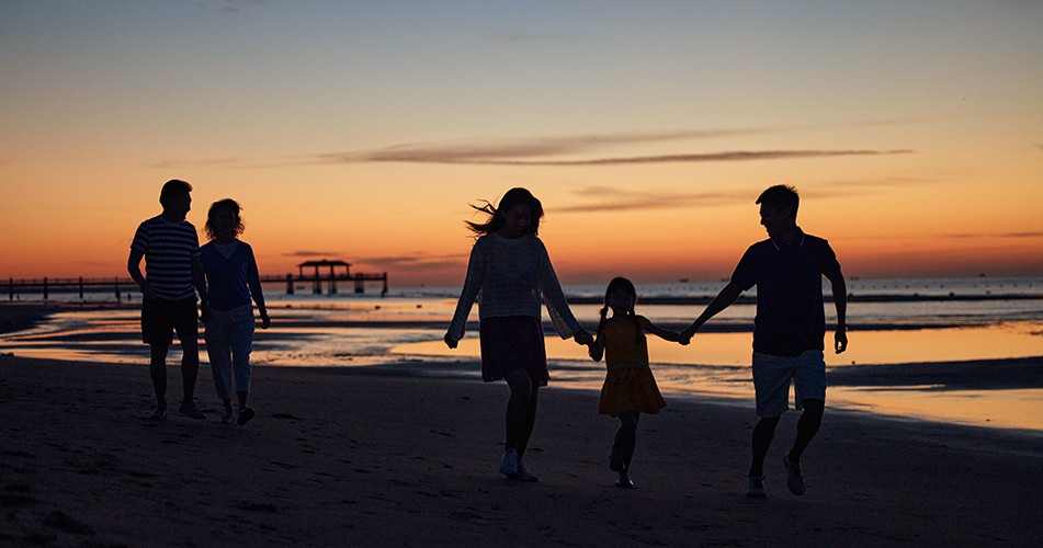 family watching sunset at the beach