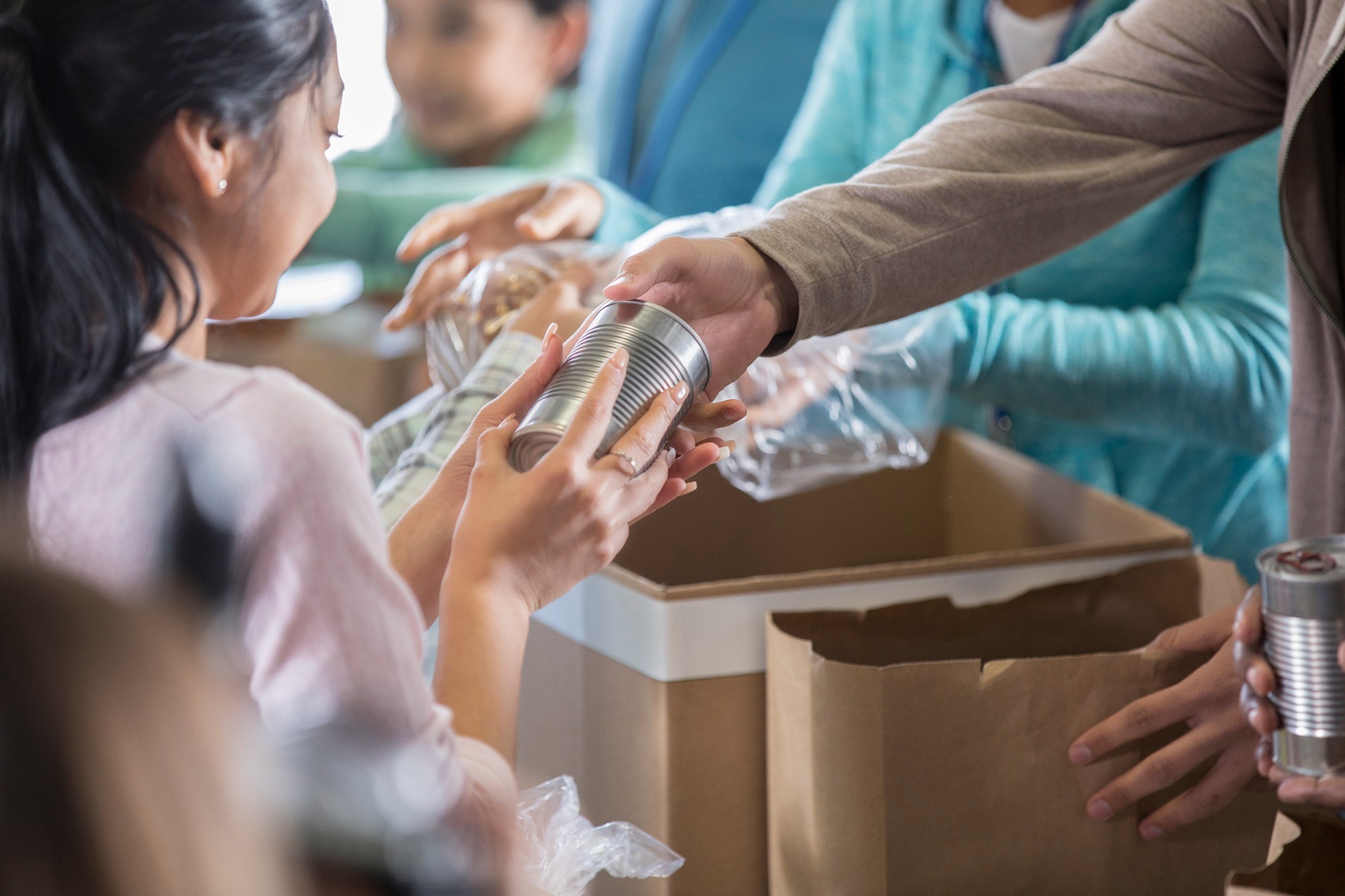 People handing food into a food bank