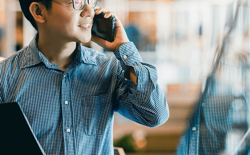 Man on phone with his reflection in background