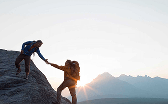 Two people climbing a mountain 