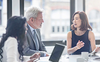 Woman talking to two other people in a business meeting