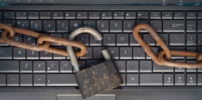  rusty chain and broken padlock on laptop keyboard