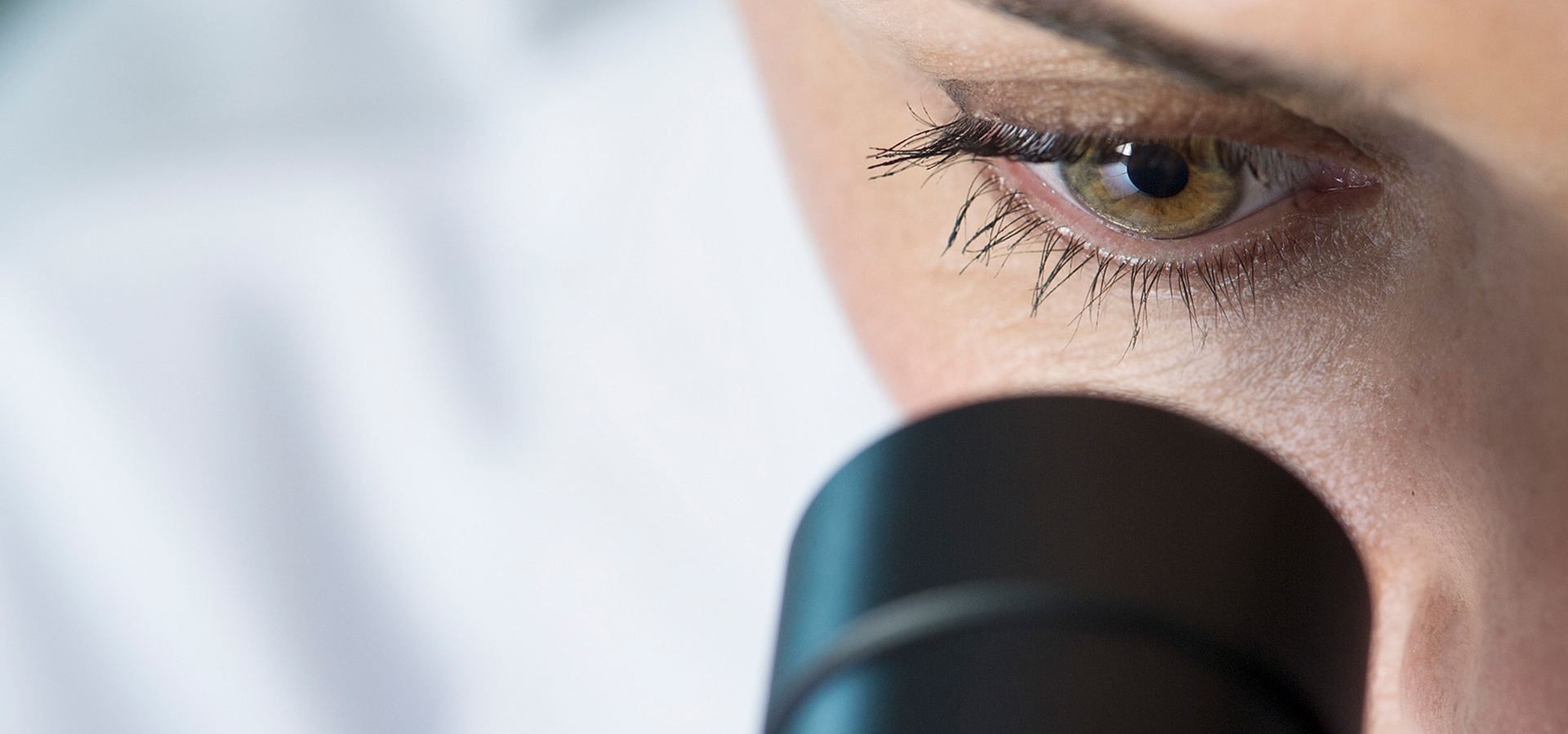 Close-up of scientist looking through a microscope